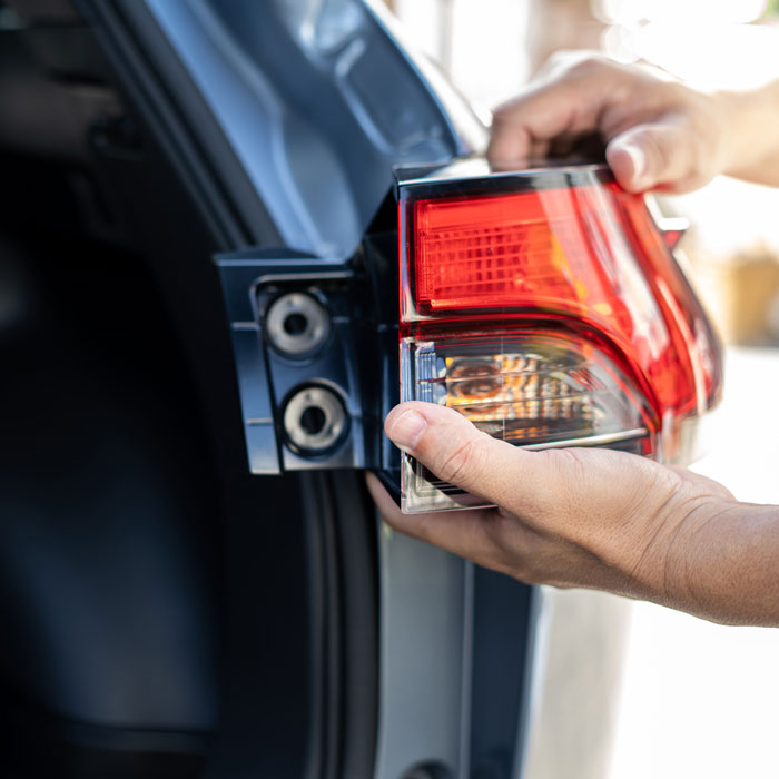 mechanic working on car headlight