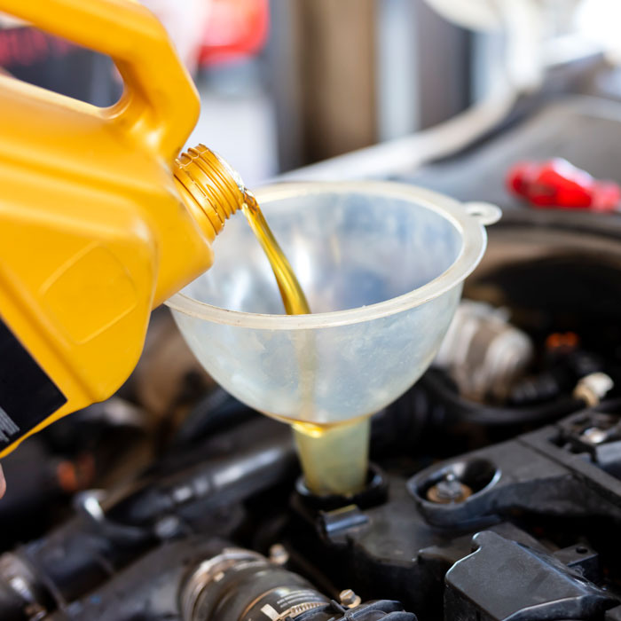 pouring oil into funnel