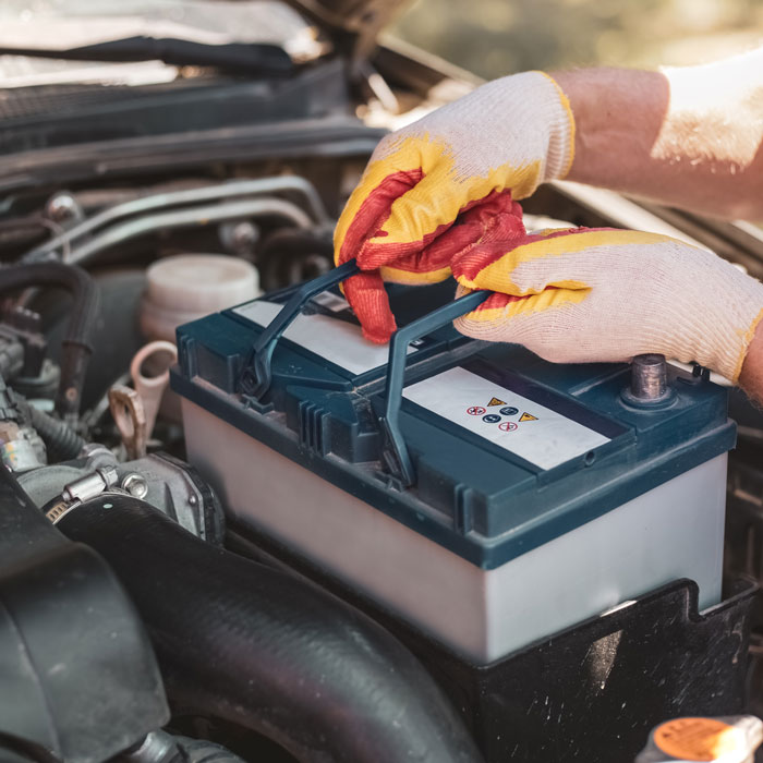 mechanic placing battery in car