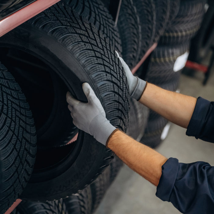mechanic grabbing tire from shelf