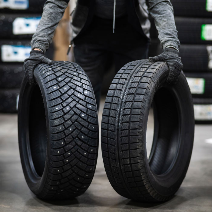 mechanic holding 2 different tires