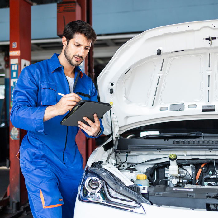 man inspecting under hood of car